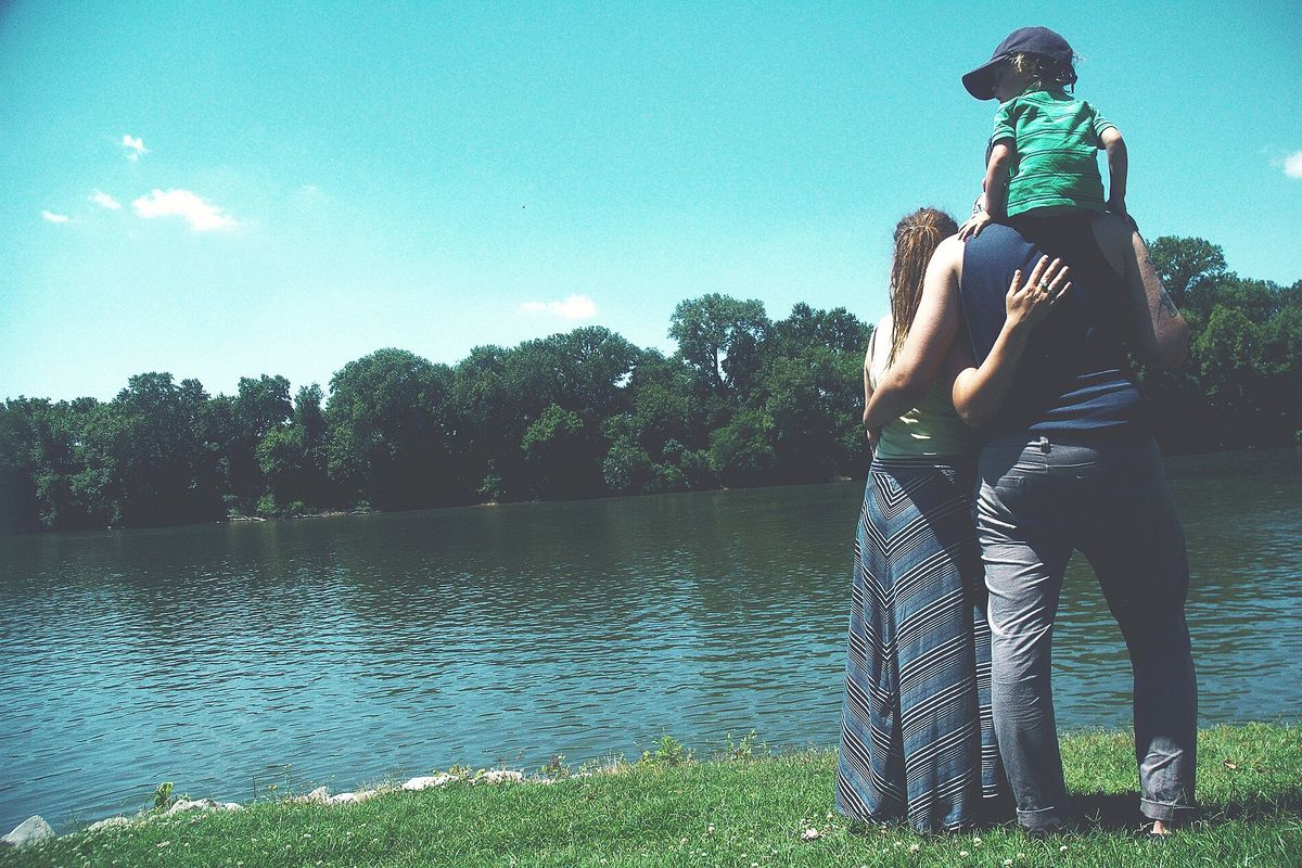 A family by a lake, seen from behind
