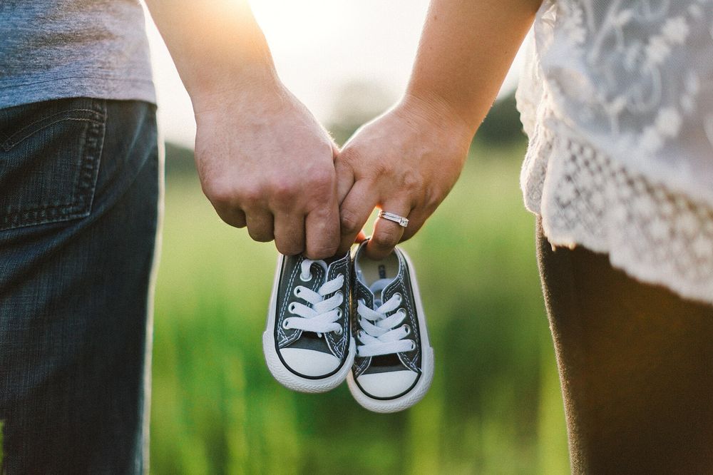Parents holding a pair of baby shoes